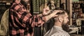 Work in the barber shop. Man hairstylist. Hairdresser cutting hair of male client. Man visiting hairstylist in Royalty Free Stock Photo