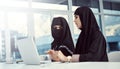 They work best together. two young arabic businesswomen working on a laptop in their office. Royalty Free Stock Photo