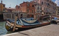 A work boat docked on a canal alongside old Venetian buildings in Venice, Italy.