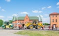 Work brigade repairing the road using crawler asphalt paver full of fresh asphalt pavement and road roller in summer. Workers Royalty Free Stock Photo