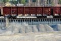 Unloading of crushed stone a railway car of a dump truck, closeup.