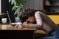 Work burnout. Tired female employee putting head down on table, suffering from chronic job stress.