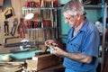 Work cabinetmaker looking handcrafted wooden pieces in garage at Royalty Free Stock Photo