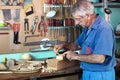 Work cabinetmaker marking handcrafted wooden pieces in garage at Royalty Free Stock Photo