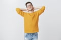 Work can wait. Portrait of carefree relaxed and lazy handsome young european man in warm sweater laying back holding Royalty Free Stock Photo