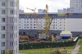 Work on the construction site. A workers` brigade mounts a tower crane. Heavy construction machinery works.