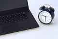 A work desk with a computer and office accessories and an alarm clock measuring the time running away. The concept of urgent deadl Royalty Free Stock Photo