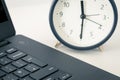 A work desk with a computer and office accessories and an alarm clock measuring the time running away. The concept of urgent deadl Royalty Free Stock Photo