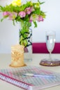 A work desk with flowers, a notebook, a glass of water and a candle. Esoteric table.