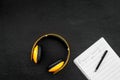 Work desk of modern composer. Music notes near headphones on black background top view copy space Royalty Free Stock Photo