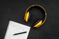 Work desk of modern composer. Music notes near headphones on black background top view copy space Royalty Free Stock Photo