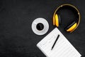 Work desk of modern composer. Music notes near headphones on black background top view copy space Royalty Free Stock Photo