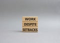 Work despite setbacks symbol. Wooden blocks with words Work despite setbacks. Beautiful grey background. Business and Work despite