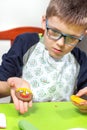 Work done by a child. A cinnamon round cookie decorated by a child. A smiling face painted with colorful iced felt-tip pens.