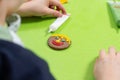 Work done by a child. A cinnamon round cookie decorated by a child. A smiling face painted with colorful iced felt-tip pens.