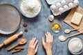 Work with the dough. The kitchen table raw ingredients, the woman`s hand ready to knead the preparing cake Royalty Free Stock Photo