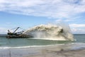 Work dredger dredging with sand washing on beaches. Special dredging hose for sand to create new land. Sand washing on sea Royalty Free Stock Photo