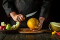 Work environment on the kitchen table before slicing a ripe melon. Knife in the chef hand. Fruit diet concept. Asian cuisine Royalty Free Stock Photo