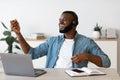 Cheerful Black Freelancer Man Listening Music And Playing Virtual Guitar At Workplace Royalty Free Stock Photo