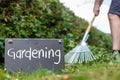 Work in the garden. Man is raking leaves of a freshly cut hornbeam hedge. The word Royalty Free Stock Photo