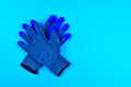 work gloves with blue rubber coating on bright blue background represent personal protective equipment for grip, safety, and Royalty Free Stock Photo