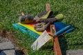 Two work gloves, a rubber mallet, a spirit level, a trowel and a foam pad lying in the grass during a break in placing