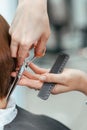The work of a hairdresser. Hairdresser cut hair of a woman  in a beauty salon. Close-up of hands Royalty Free Stock Photo
