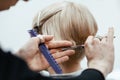 The work of a hairdresser. Hairdresser cut hair of a woman. Close-up of hands and tool. Royalty Free Stock Photo