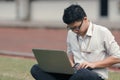 Work hard Asian business man using laptop on the green grass. Royalty Free Stock Photo