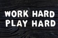 Work Hard Play Hard words on dark wooden background