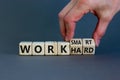 Work hard or smart symbol. Businessman turns wooden cubes and changes words `work hard` to `work smart`. Beautiful grey backgr