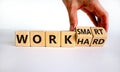 Work hard or smart symbol. Businessman turns wooden cubes and changes words `work hard` to `work smart`. Beautiful white