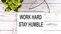 WORK HARD STAY HUMBLE text concept write on notebook on wooden background Royalty Free Stock Photo