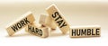 Work Hard, Stay Humble Text written on wooden blocks and white background.