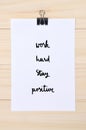 Work hard Stay positive on white paper with wooden background