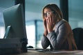 Work has its ups and downs. a young businesswoman looking stressed out while working late in an office. Royalty Free Stock Photo