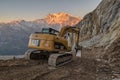 Work at high altitudes in the mountains. Caterpillar excavator, Cat