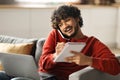 Work From Home. Young Indian Man Talking On Cellphone And Taking Notes Royalty Free Stock Photo