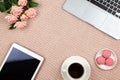 Work from home concept. Modern female working space, top view. Laptop, coffee, cakes, roses, tablet on knitted blanket, copy space Royalty Free Stock Photo