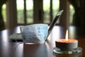 Work at home during coronavirus outbreak. Focus on face mask with computer laptop and burning candle on table Royalty Free Stock Photo