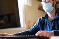 Work from home COVID-19 concept. Asia man wear medical mask using notebook computer working for social distancing meeting online Royalty Free Stock Photo