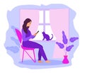 Work at home, freelance. Girl works on a smartphone near the window. A young woman sits on a chair in the house, a cat