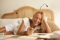 Work From Home. Mature Woman Uses Notepad Sitting On Bed. Beauty Portrait Of Middle Age Female Studying And Working. Royalty Free Stock Photo