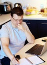 Work at home online during a pandemic 2019-ncov. Focused and serious young man in glasses takes some notes