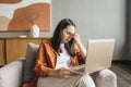 A young beautiful European woman in a state of stress and burnout, anxiety, fatigue, working at a laptop at home. Royalty Free Stock Photo