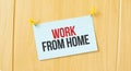 WORK FROM HOME sign written on sticky note pinned on wooden wall Royalty Free Stock Photo