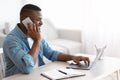 Work From Home. Smiling Black Freelancer Guy Using Laptop And Cellphone Royalty Free Stock Photo