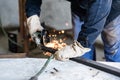 Work at home workshop. Man cuts the metal profile with electric angle grinder Royalty Free Stock Photo