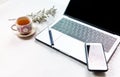 Work from home, workspace office at home, Notebook or laptop computer with pen mobile phone and Chinese tea cup  on the white desk Royalty Free Stock Photo