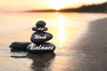 Work-life balance. Stacked stones on sandy beach at sunset, space for text Royalty Free Stock Photo